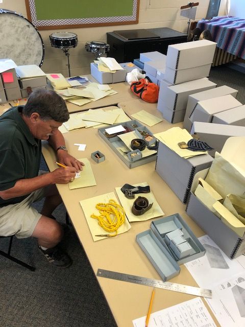 Butch Maisel ’72 carefully records research for each piece of McDonogh School military insignia so it can eventually be cataloged into a content management database system.